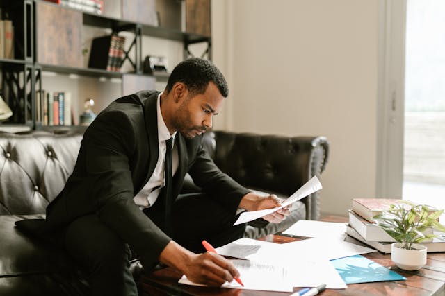 person looking over documents on their couch in an office